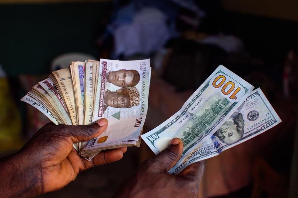 Man holds Nigerian vs U.S. currency