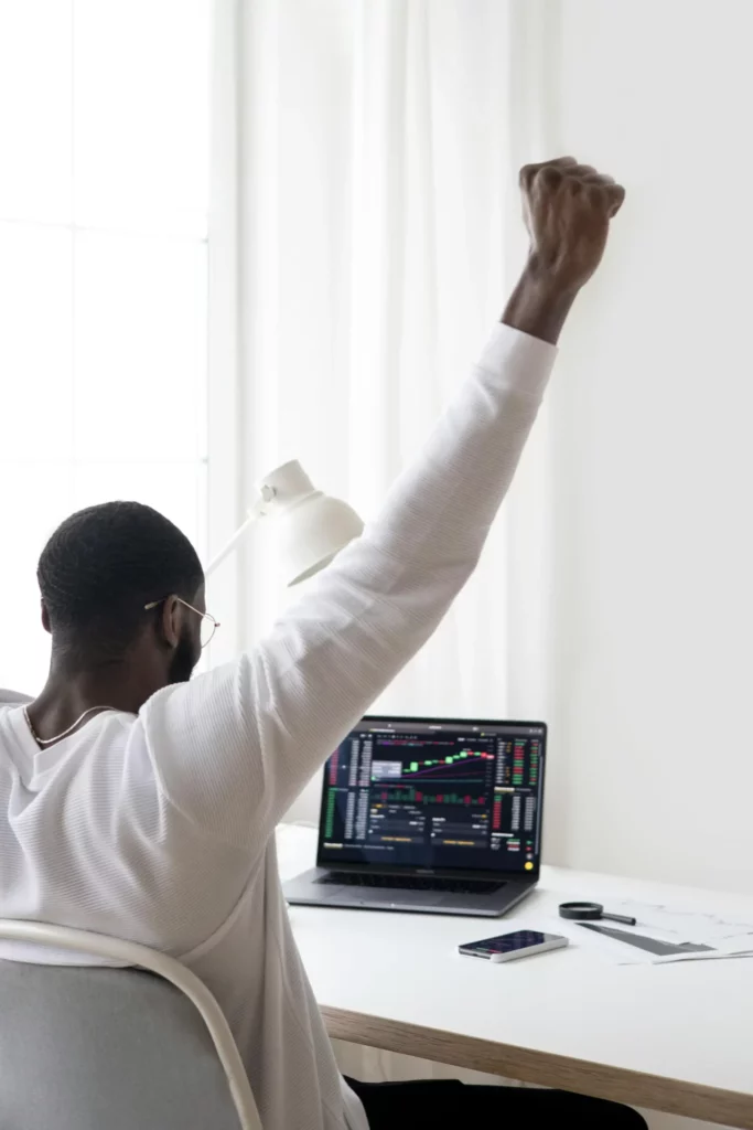 Man sitting in front of computer celebrating passing a Prop Firm Challenge on his first try