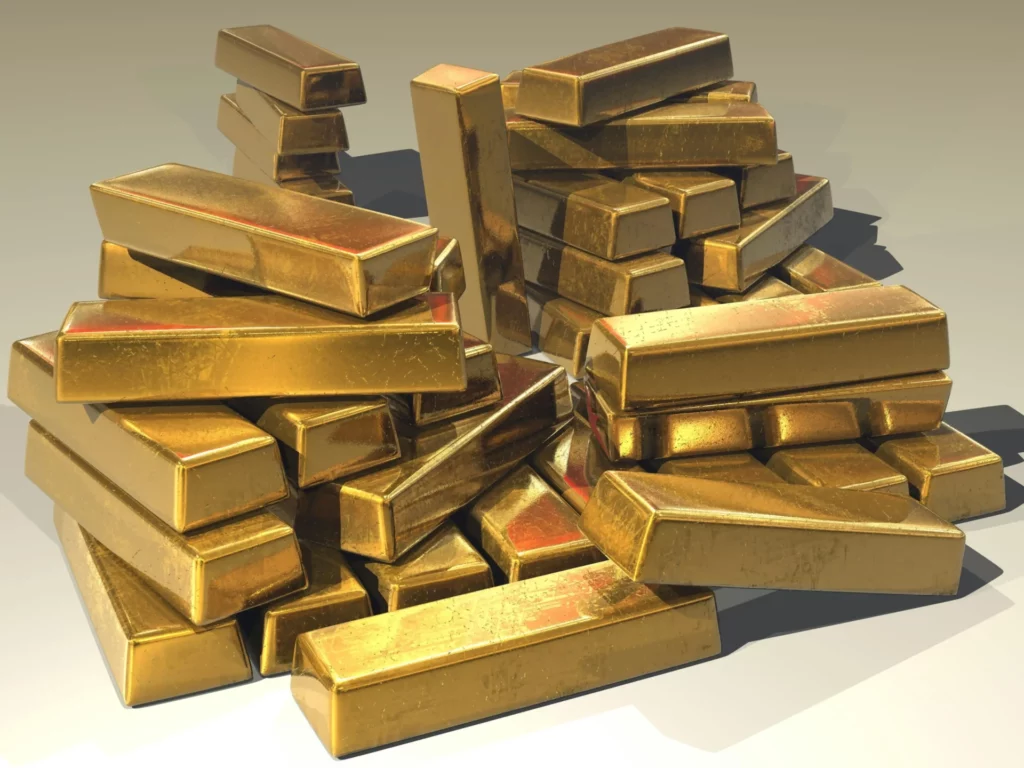 A large, shiny pile of gold bars stacked haphazardly on a white background.