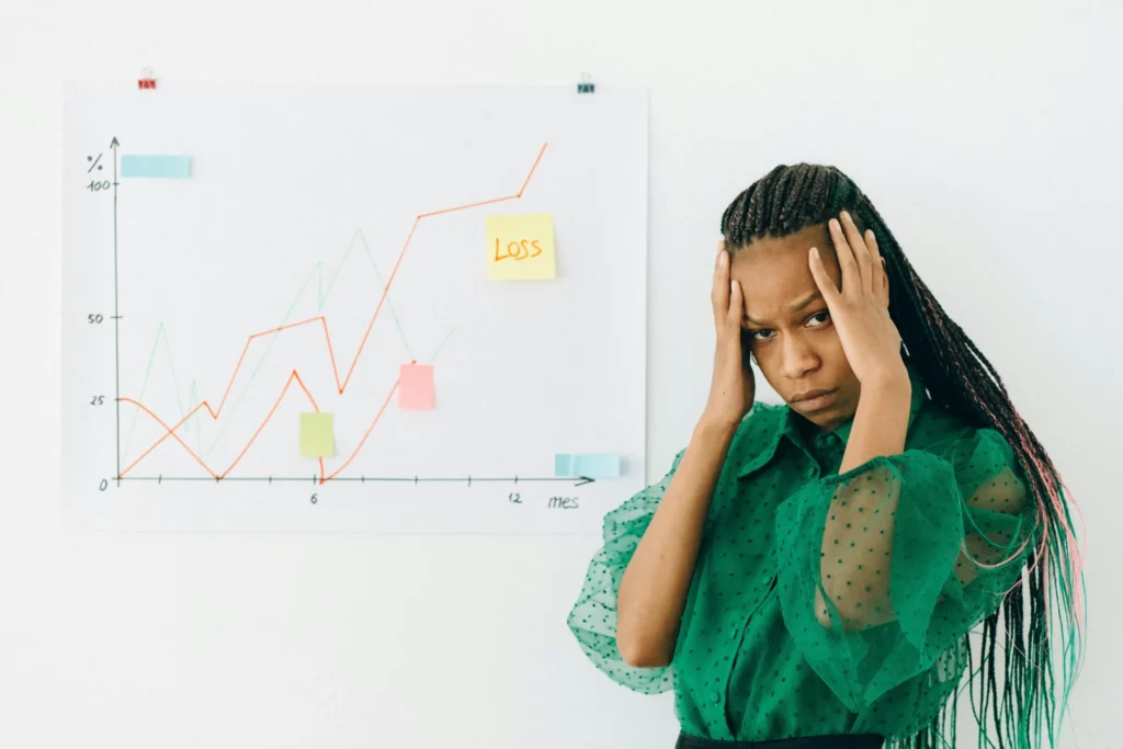 Stressed woman analyzing loss graph, showing prop firm trading mistakes impact. 
